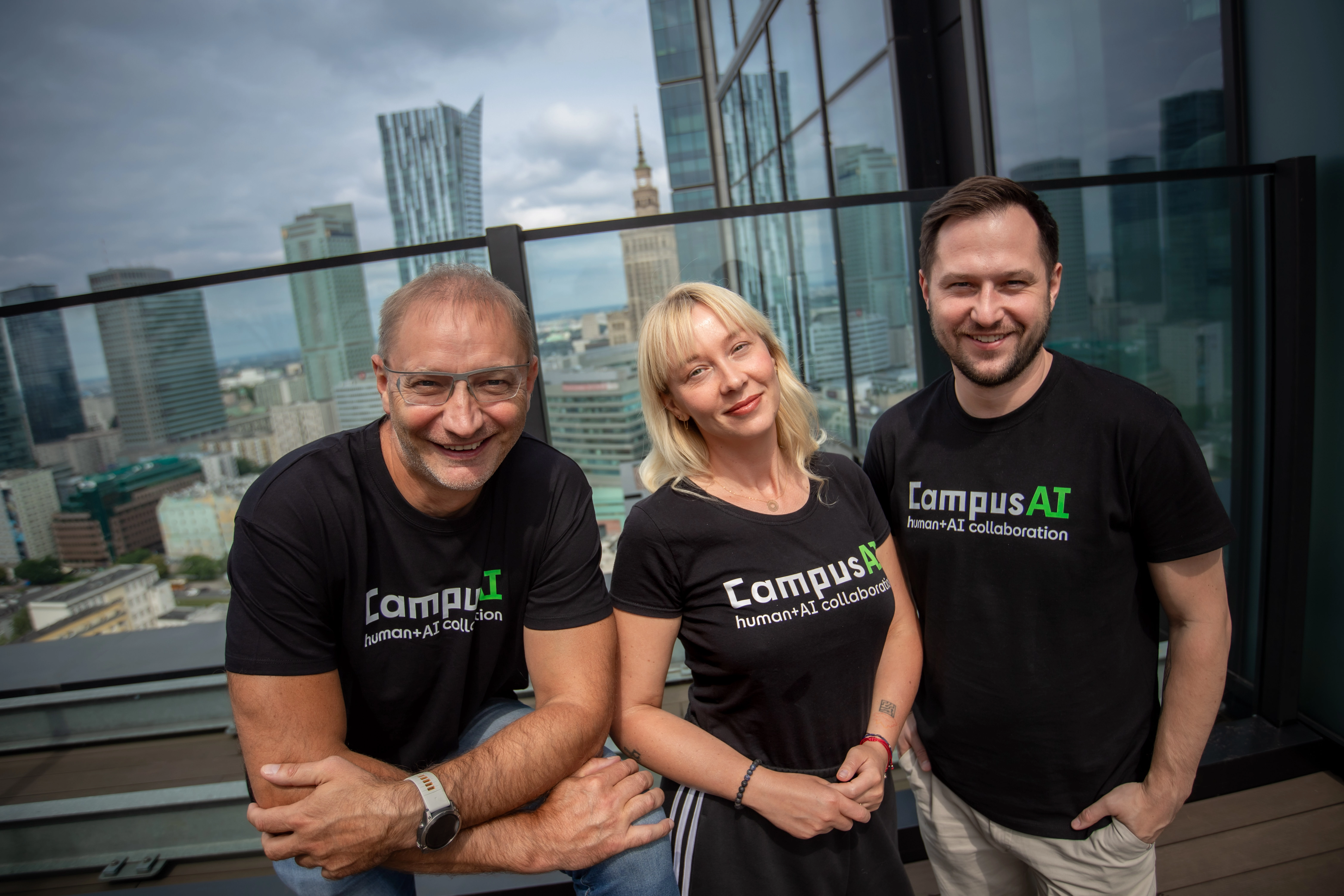 CampusAI team - three people wearing CampusAI t-shirts on rooftop with city skyline background